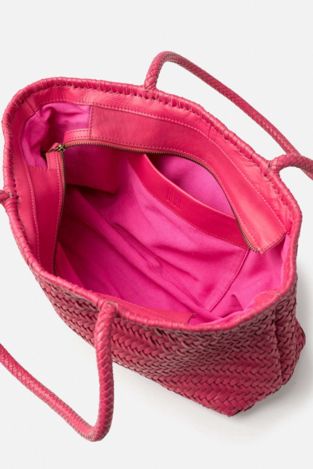 Intérieur du cabas BIBA en cuir tressé rose fuchsia avec doublure rose et poche zippée