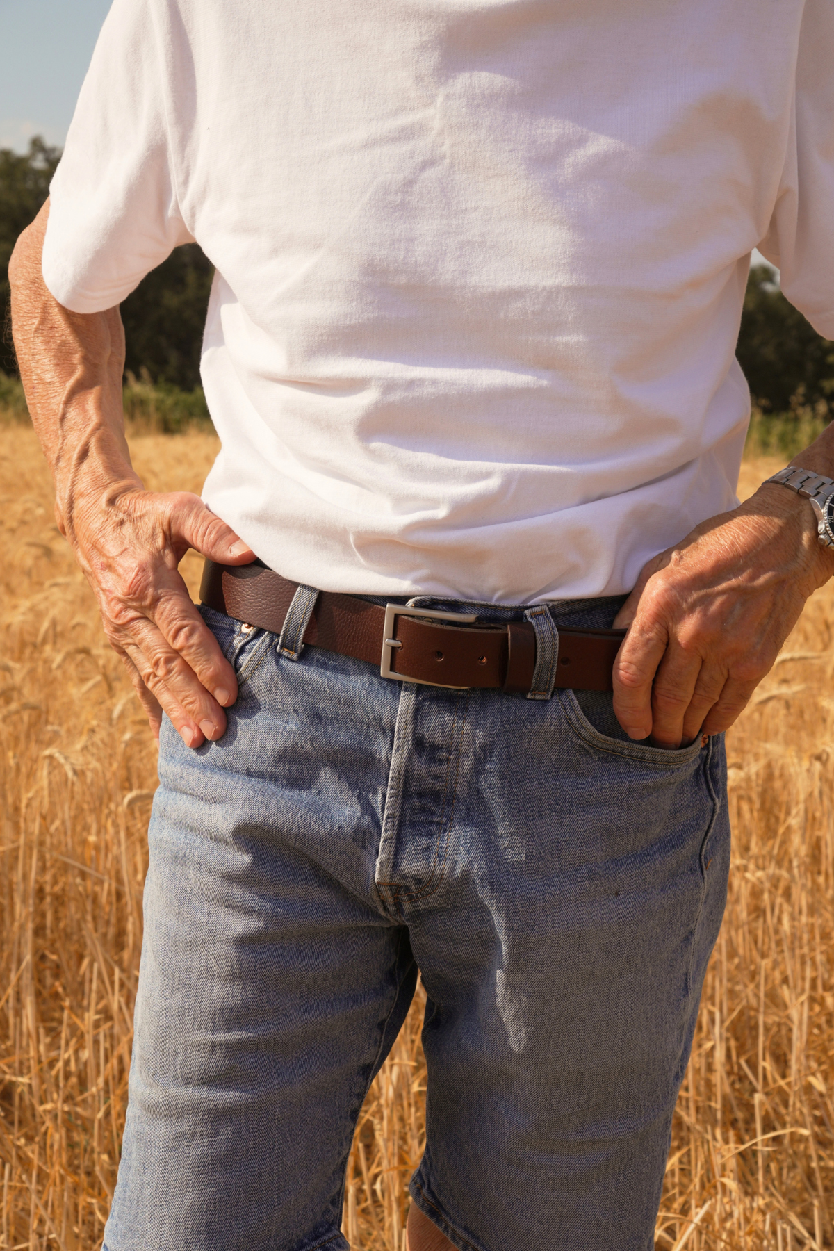 Ceinture homme Roger Atelier Nappa en cuir marron foncé à boucle argentée, portée sur un jean