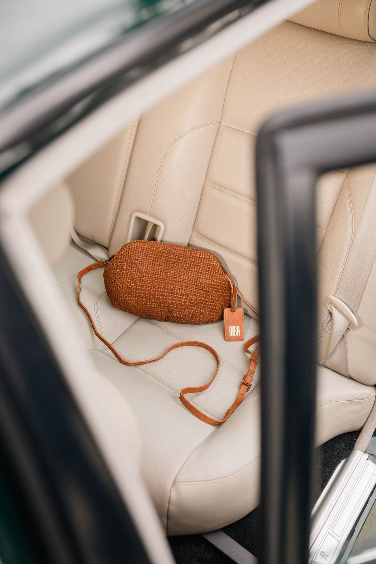 Petit sac à main tressé fin cuero - fermeture magnétique - sac en bandoulière couleur cuir naturel - pochette soirée posé sur un siège