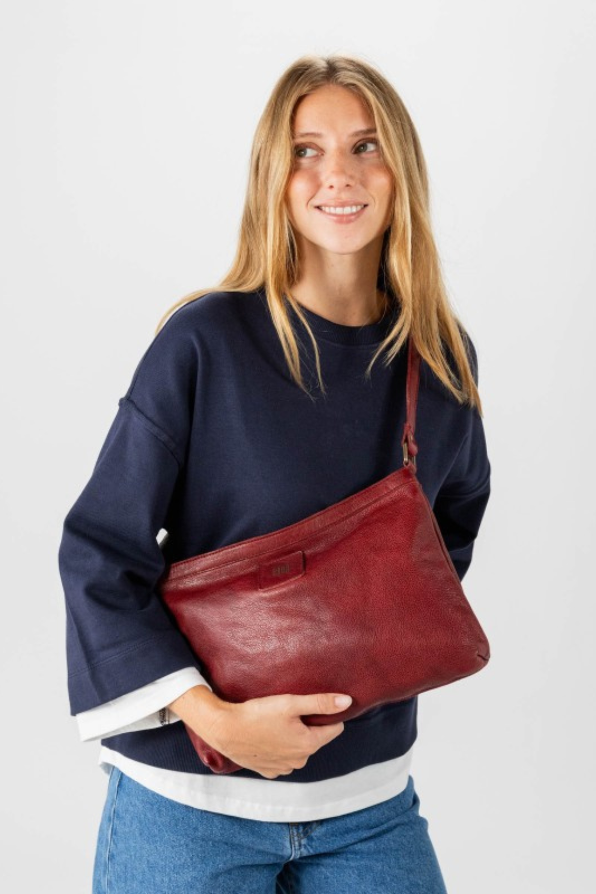 Sac bandoulière en cuir rouge Biba Boston porté croisé avec un pull marine