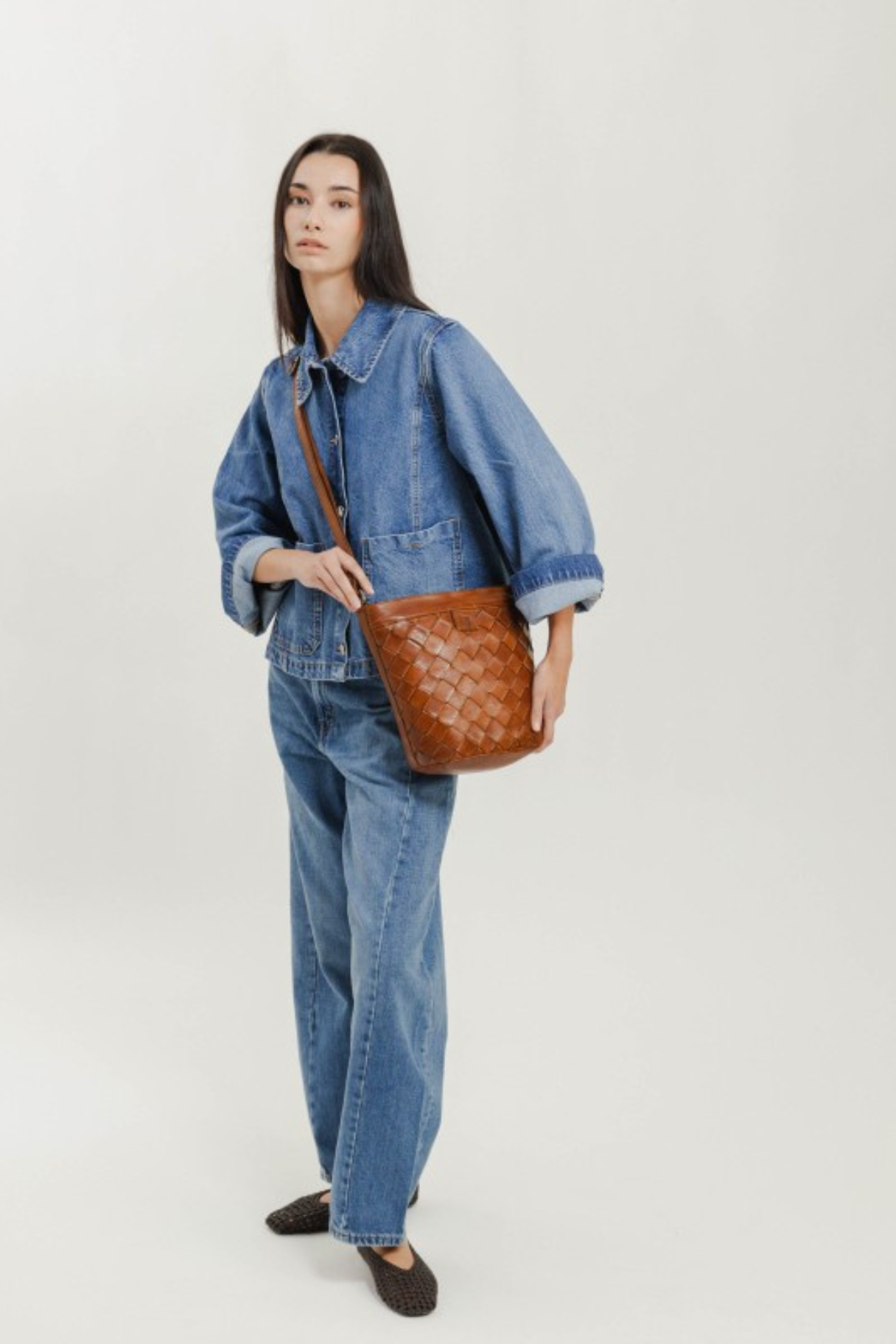 Sac bandoulière en cuir tressé cognac Biba porté croisé avec un ensemble en jean