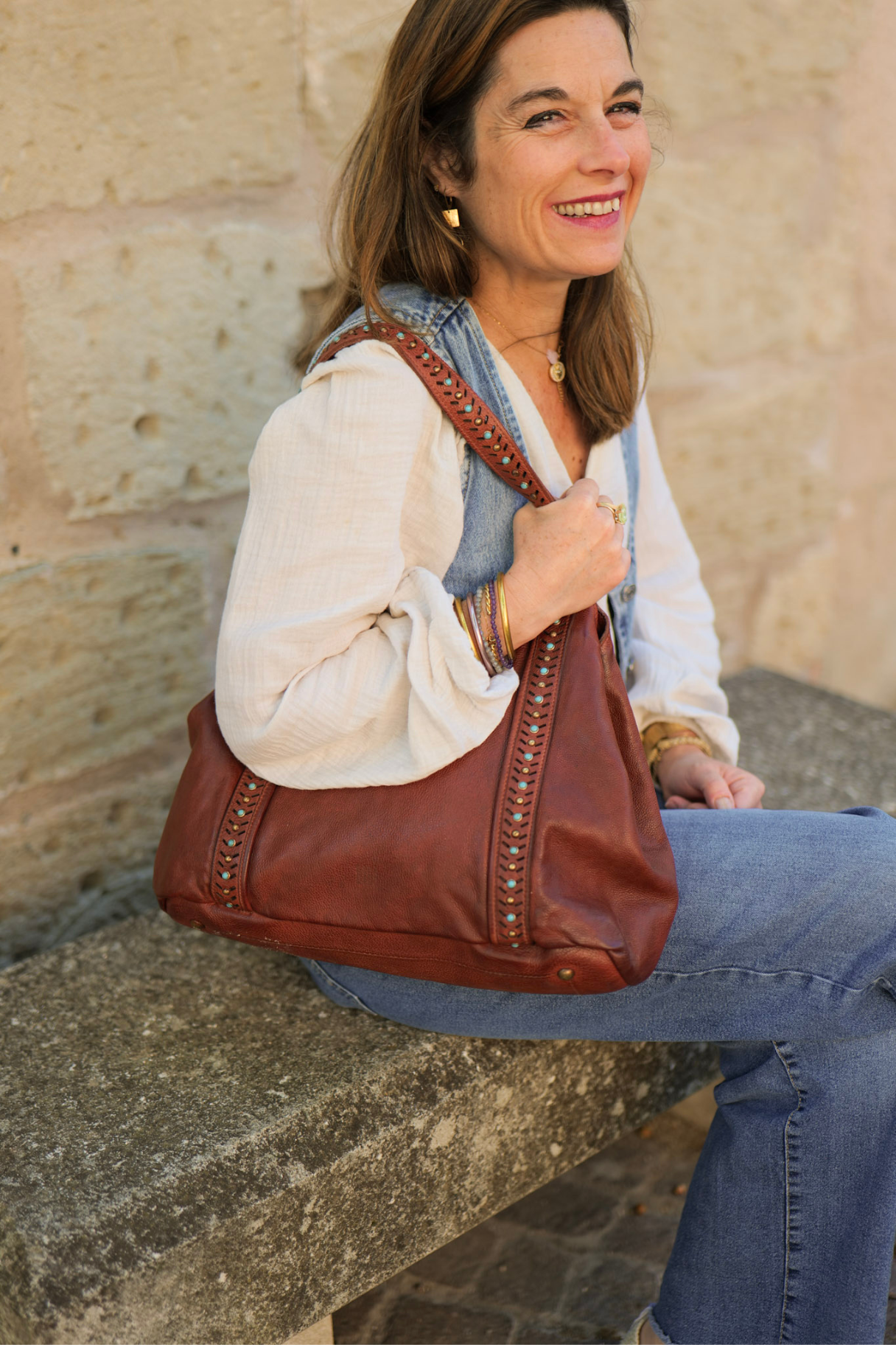 Sac porté épaule en cuir marron cognac avec détails perlés turquoise et clous dorés, look bohème chic
