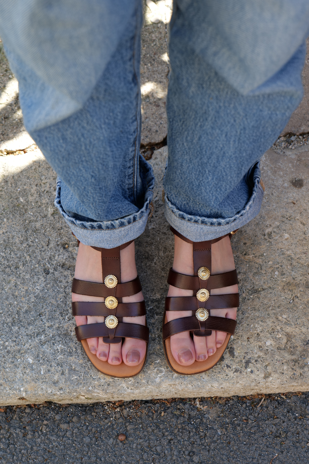 Sandales femme cuir marron Eva Frutos avec ornements ronds dorés portées avec un jean retroussé