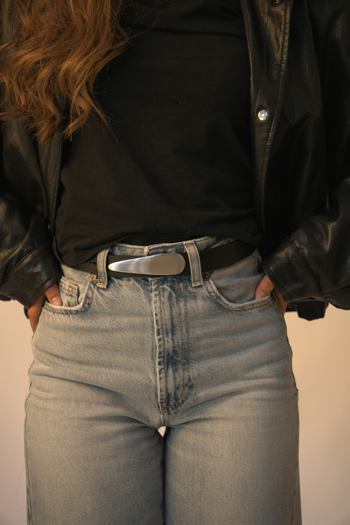 Ceinture femme en cuir noir Rosa Atelier Nappa à boucle goutte d'eau, portée sur un jean taille haute