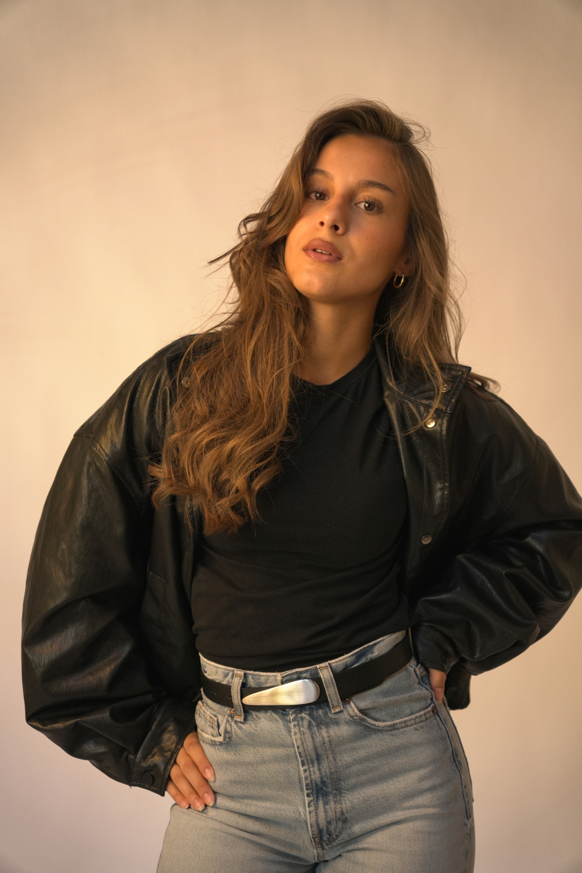 Ceinture Rosa Atelier Nappa en cuir noir à boucle goutte d'eau argentée, portée sur un jean clair avec un t-shirt noir et une veste en cuir