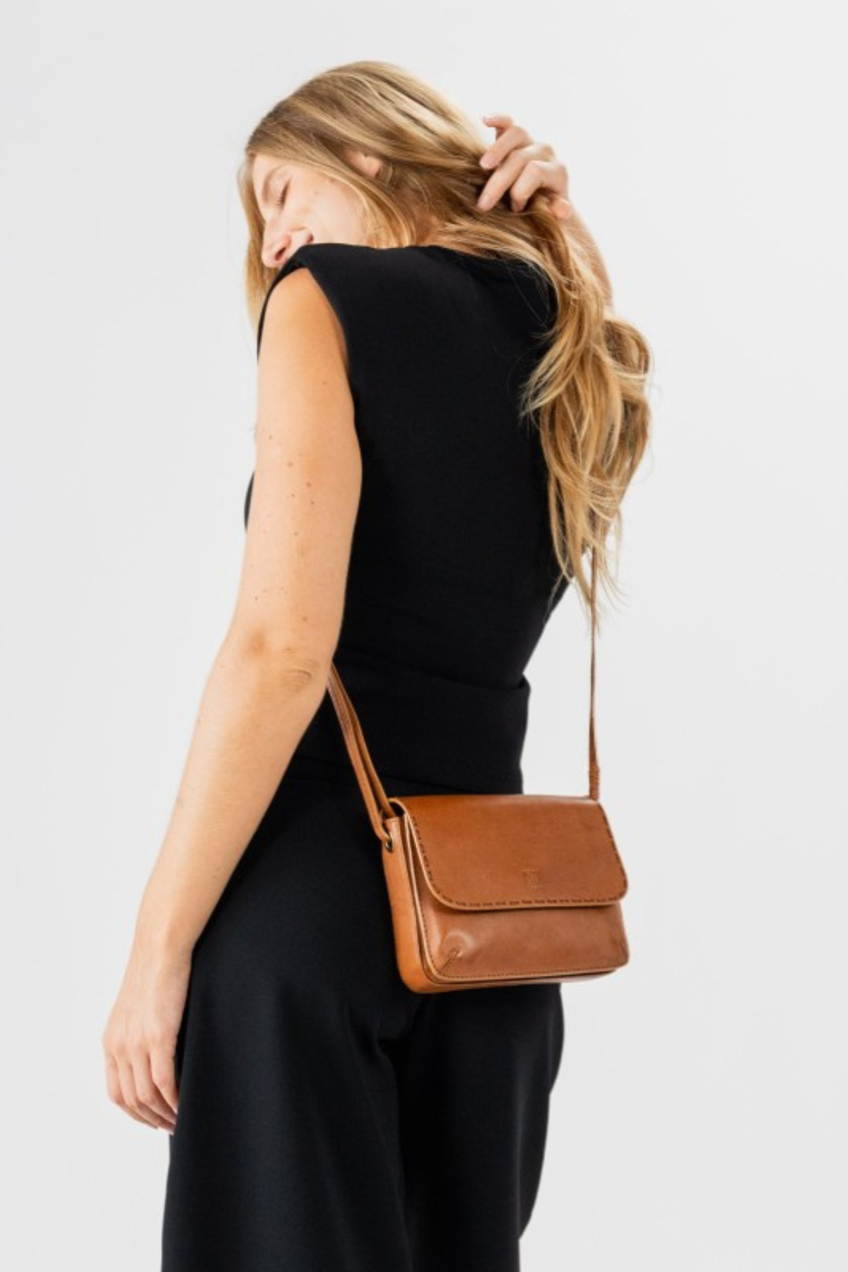 Petit sac bandoulière en cuir camel Biba Hatch porté croisé avec une robe noire