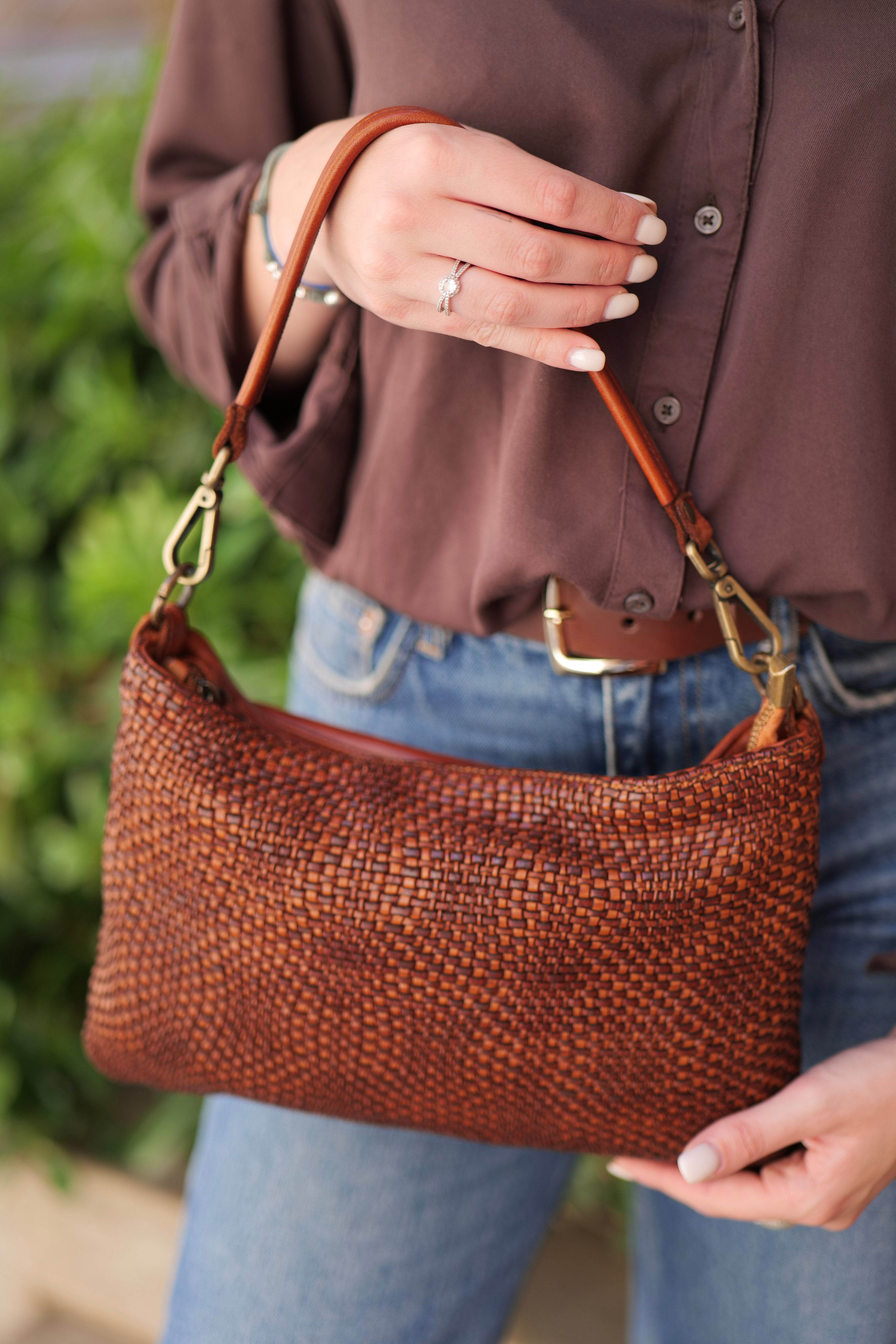 gros plan sur la pochette marron tenue à la main