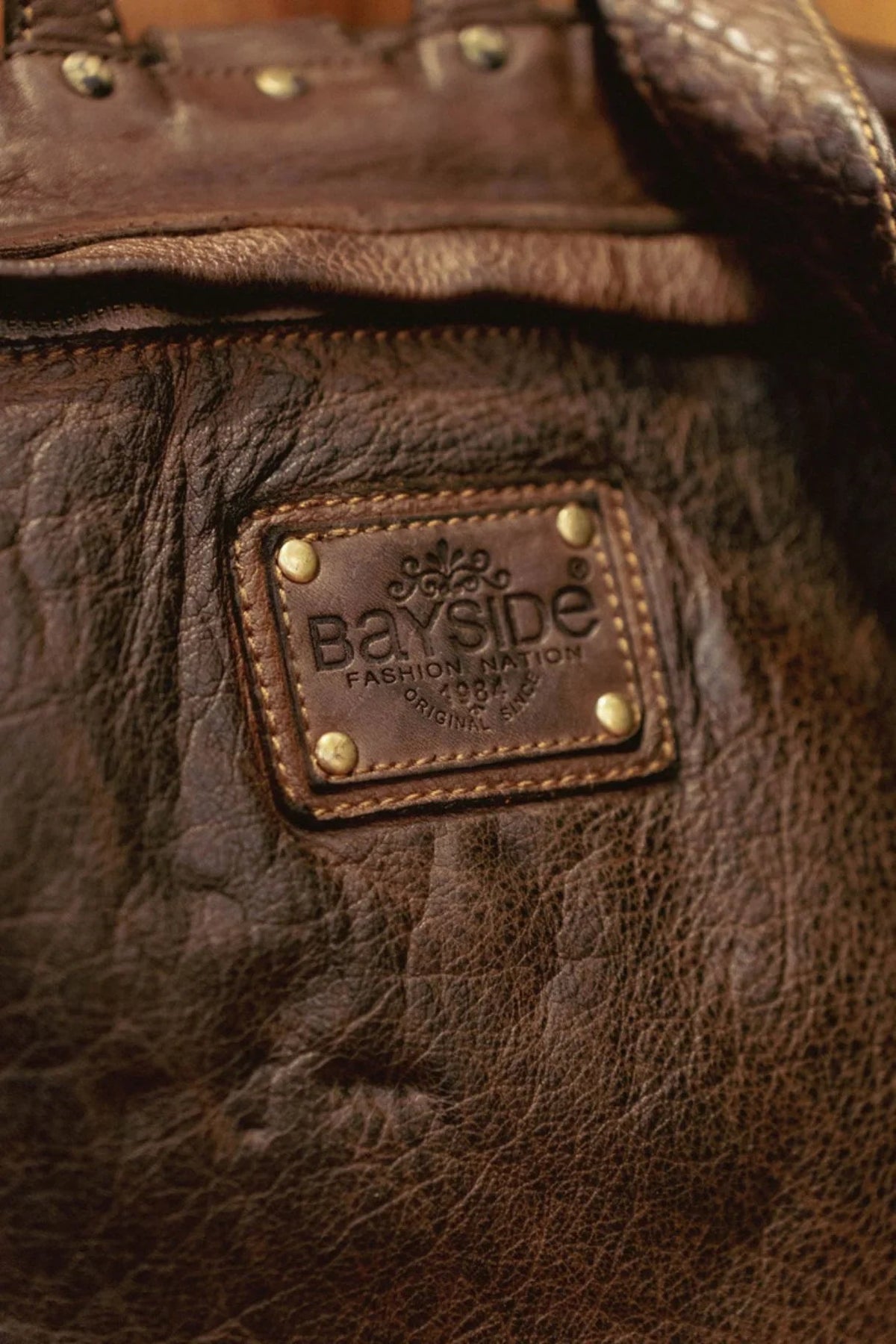 Détail de l'étiquette en cuir Bayside sur le sac à dos Bologne marron foncé