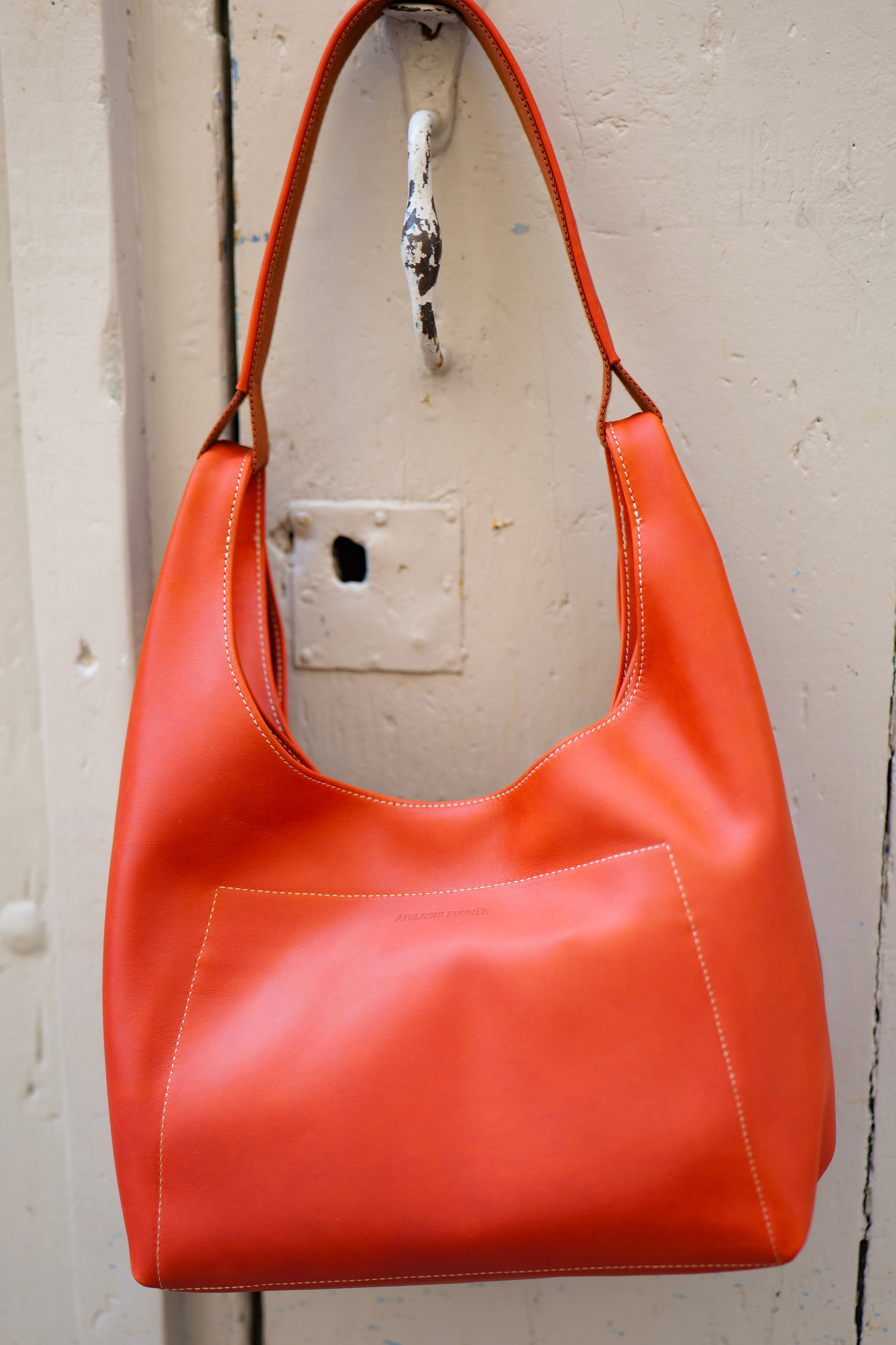 Vue du sac Amazone orange suspendu à une porte