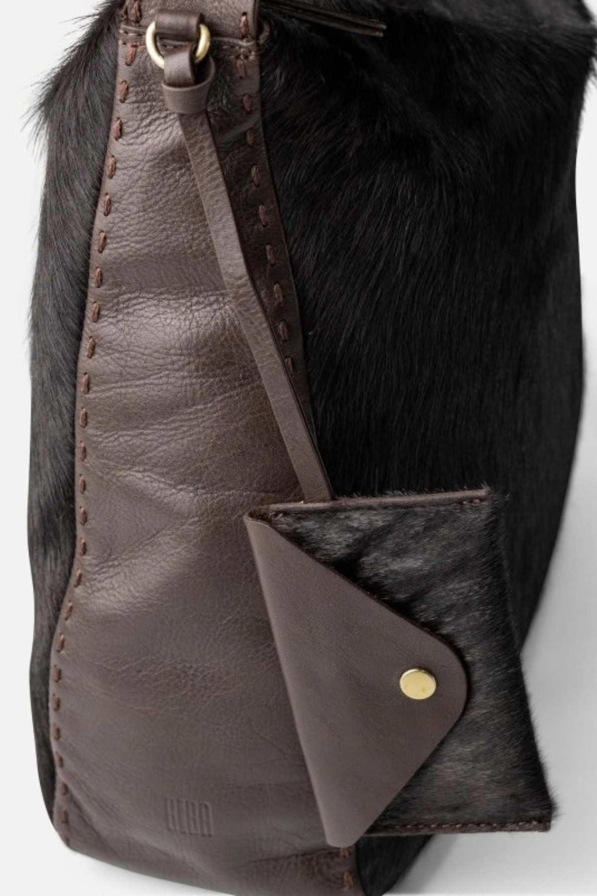 Détail de la mini pochette suspendue à bouton doré et des surpiqûres au point sellier du sac Genola Biba