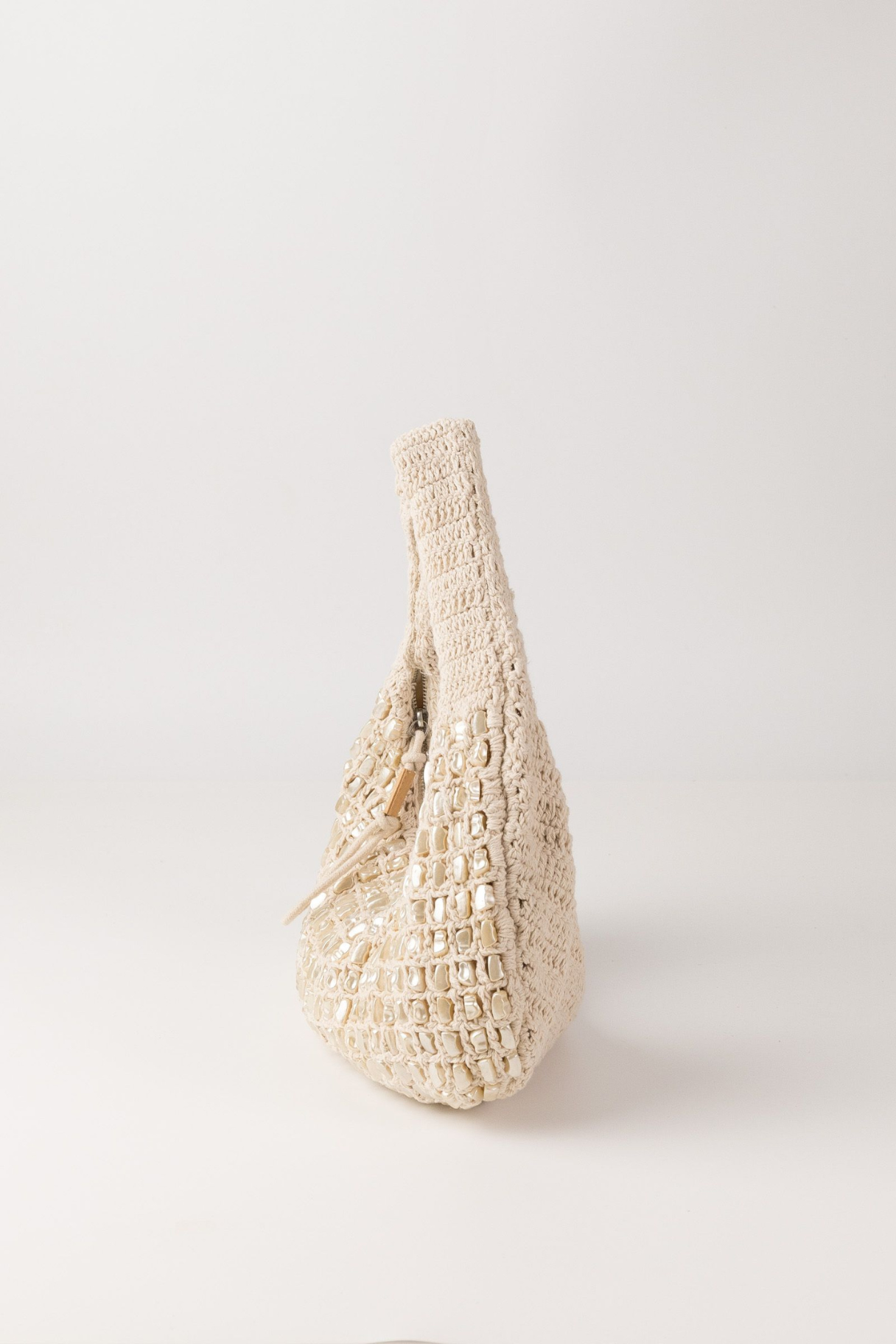 Sac hobo Shell Biba vue de profil, forme croissant en crochet écru et perles de nacre